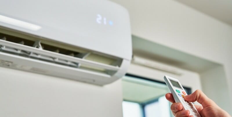 hand adjusting temperature on air conditioner picture