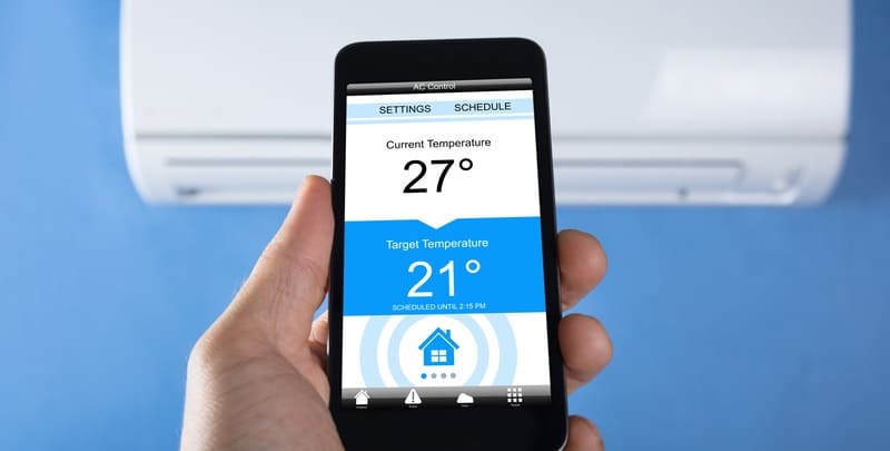 Hand holding a smart phone to control air conditioner