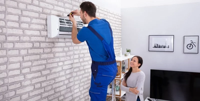 male technician repairing air conditioner with screwdriver