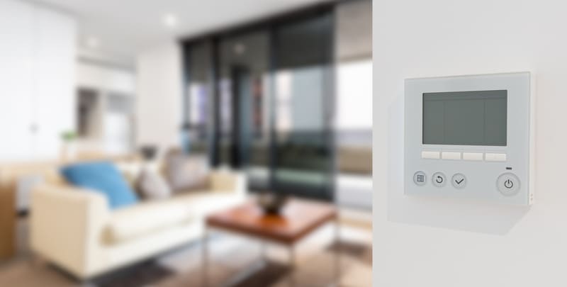 blurred photo of living room with control panel of ducted reverse cycle air conditioning system in focus